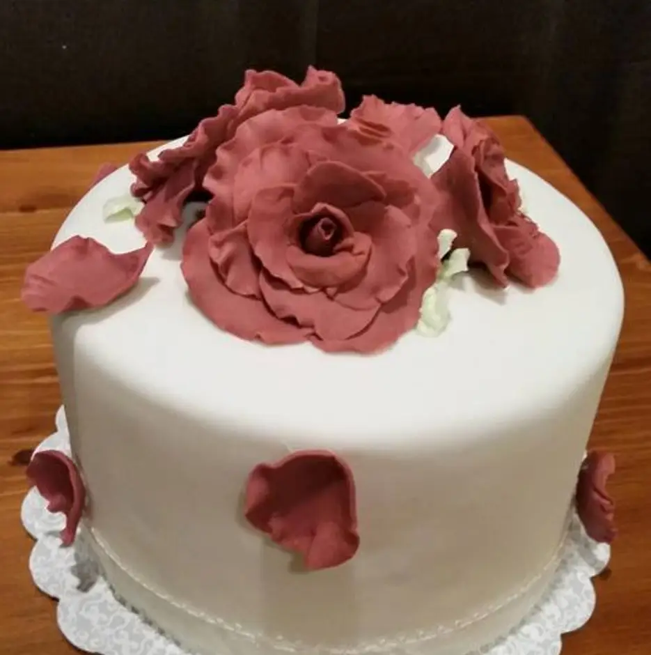 White celebration cake decorated with deep pink sugar roses